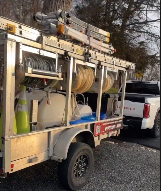 Equipment trailer with hose reels, soft-wash tanks, and ladders